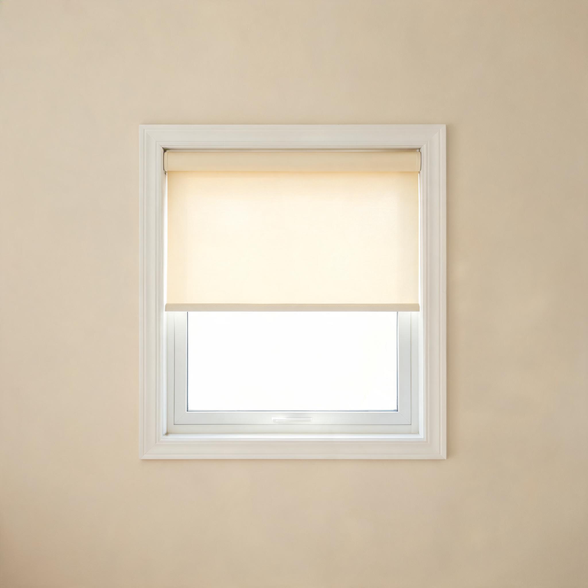 Roller shade in warm ivory fabric.